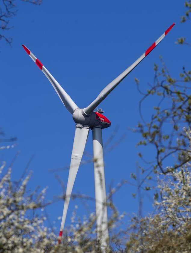 Das Foto zeigt die Turbine und die Rotorblätter einer Windkraftanlage.
