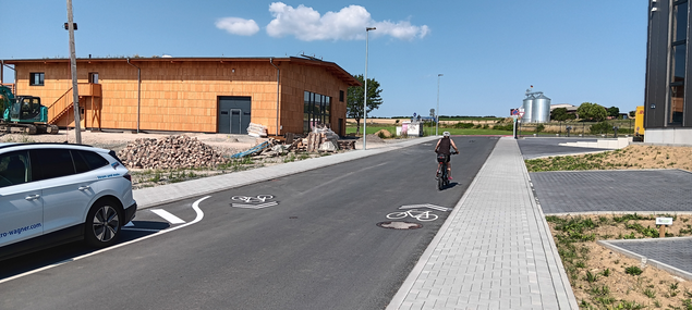 Radfahrer in Gewerbegebiet auf Radweg mit Piktogramm